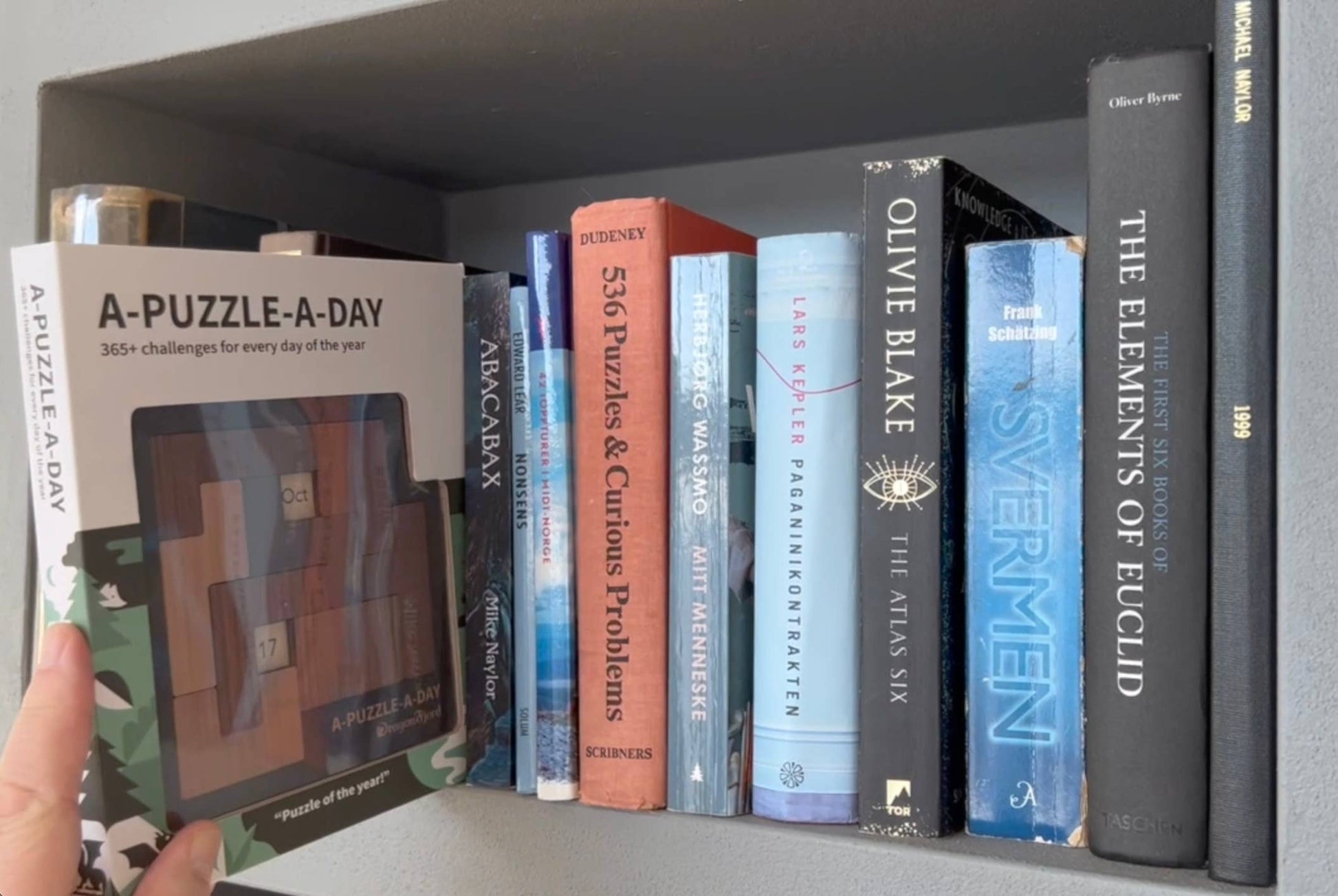 A-Puzzle-A-Day Deluxe komplett sett med magnetboks som passer perfekt i bokhylla