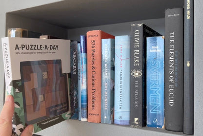 A-Puzzle-A-Day Deluxe komplett sett med magnetboks som passer perfekt i bokhylla