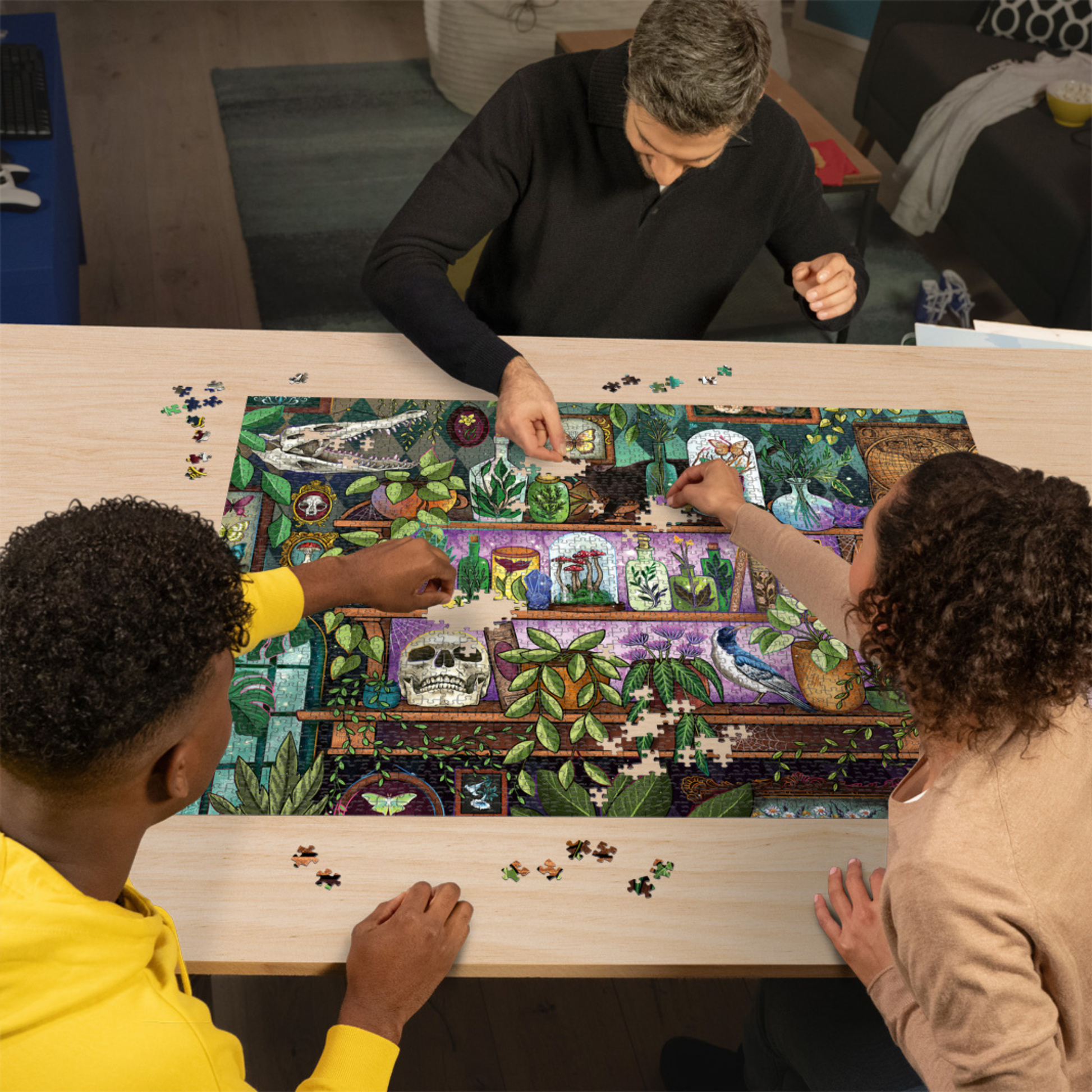 Personer pusler Ravensburger puslespill ved trebord med puslespillbrikker spredt rundt
