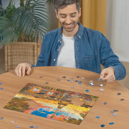 Person pusler Ravensburger puslespill ved trebord med puslespillbrikker spredt rundt